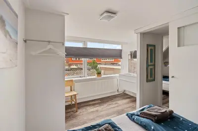 a bedroom with a bed and a large window at Have e nice stay! - Juul 18, free parking in Noordwijk