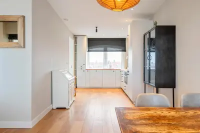 a dining room with a table and a window at Sandhues Beachfront Apartment in Zandvoort