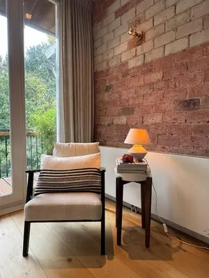 a room with a chair and a table with a lamp at The Park Loft in Amsterdam