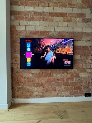 a flat screen tv hanging on a brick wall at The Park Loft in Amsterdam