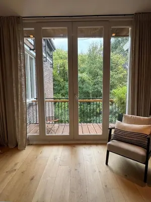 a room with a sliding glass door with a chair at The Park Loft in Amsterdam
