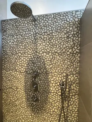 a bathroom with a shower with a mosaic wall at The Park Loft in Amsterdam