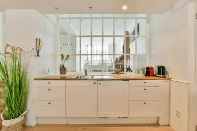 a white kitchen with a sink and a window at Palm Beach apartments in Zandvoort