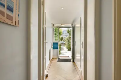 a hallway with white walls and a door to a yard at Palm Beach apartments in Zandvoort