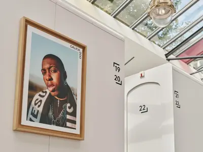 a framed picture of a rapper hanging on a wall at CityHub Amsterdam in Amsterdam