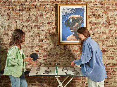 two women standing next to a table in a brick wall at CityHub Amsterdam in Amsterdam