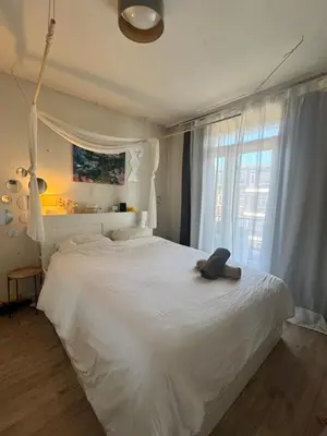 a bedroom with a white bed with a teddy bear on it at Cozy & Sunny apartment in Amsterdam west in Amsterdam