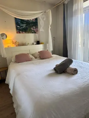 a large white bed with a pillow on top of it at Cozy & Sunny apartment in Amsterdam west in Amsterdam