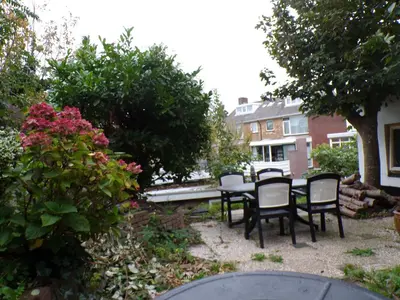 a backyard with a table and chairs and flowers at Beach Quarter in Ons Belang