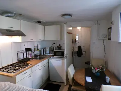 a small kitchen with white cabinets and a table at Beach Quarter in Ons Belang