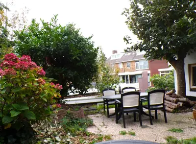 a patio with a table and chairs in a yard at Beach Quarter in Ons Belang