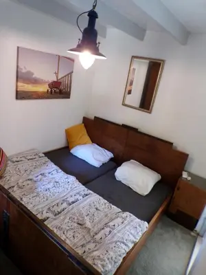 a small bedroom with a bed with two pillows at Beach Quarter in Ons Belang