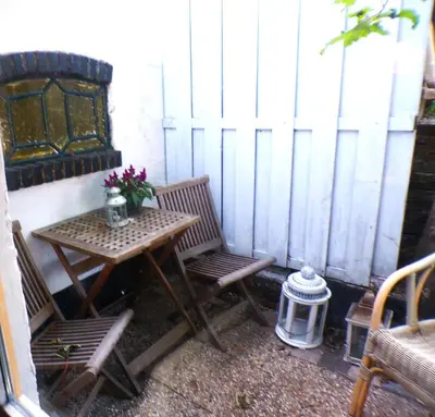a small table and two chairs on a patio at Beach Quarter in Ons Belang