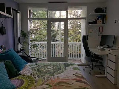 a bedroom with a desk with a computer and a window at Apartment in Museumplein in Amsterdam