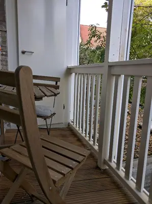 a porch with a chair and a table and a window at Apartment in Museumplein in Amsterdam