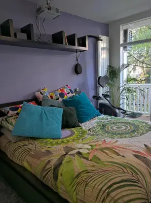 a bed with colorful sheets and pillows in a bedroom at Apartment in Museumplein in Amsterdam