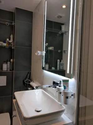 a bathroom with a white sink and a mirror at Apartment in Museumplein in Amsterdam