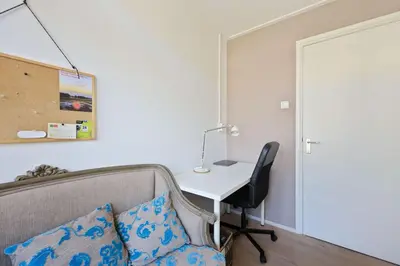 a room with a desk and a couch and a table at Cozy place many rooms in Amsterdam
