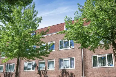a brick building with trees in front of it at Cozy place many rooms in Amsterdam