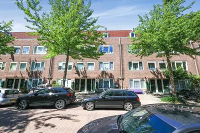 two cars parked in a parking lot in front of a building at Cozy place many rooms in Amsterdam