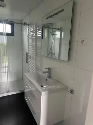 a white bathroom with a sink and a mirror at Stylish chalet in nature near Amsterdam in Halfweg