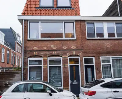 a brick house with two cars parked in front of it at Klein Witje in Haarlem