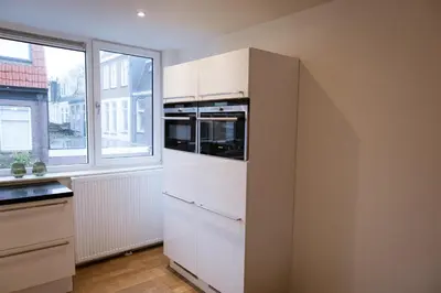 a kitchen with a white refrigerator and a window at Klein Witje in Haarlem
