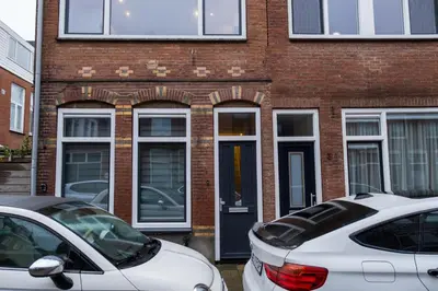 two cars parked in front of a brick building at Klein Witje in Haarlem