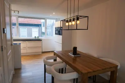 a kitchen and dining room with a wooden table and chairs at Klein Witje in Haarlem
