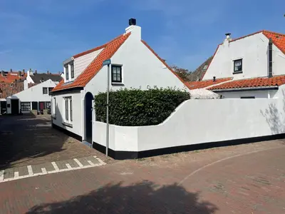 a white house with a hedge in front of it at Vissershuisje Achterom 4 in Zandvoort
