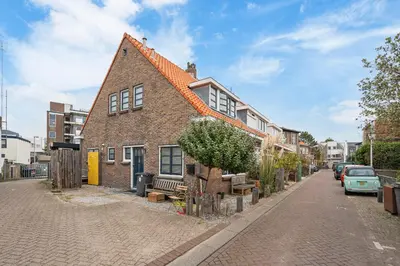 a brick house with an orange roof on a street at Studio Elysium in Zandvoort