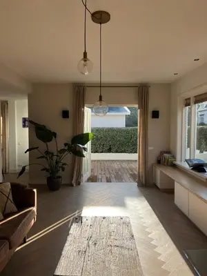 a living room with a couch and a table at Luxurious sunny beach villa in Noordwijk