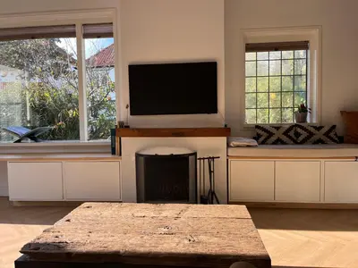 a living room with a fireplace and a flat screen tv at Luxurious sunny beach villa in Noordwijk