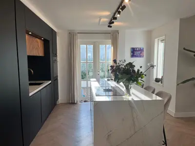 a kitchen with a large white island in a room at Luxurious sunny beach villa in Noordwijk