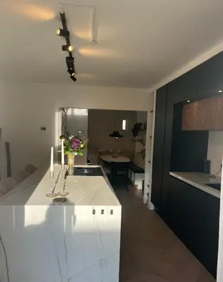 a kitchen and living room with a white counter top at Luxurious sunny beach villa in Noordwijk