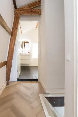 a hallway with white walls and wooden beams and a mirror at Prinsen Terrace - Boutique apartment in the Centre in Amsterdam