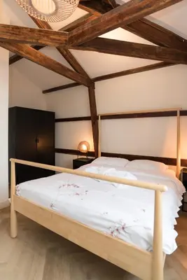 a bedroom with a large bed with wooden beams at Prinsen Terrace - Boutique apartment in the Centre in Amsterdam