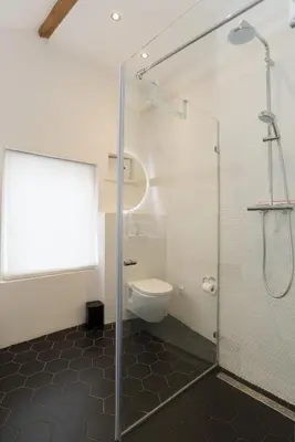 a bathroom with a glass shower and a toilet at Prinsen Terrace - Boutique apartment in the Centre in Amsterdam