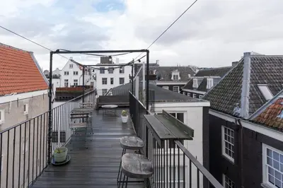 a balcony with chairs and tables and buildings at Prinsen Terrace - Boutique apartment in the Centre in Amsterdam