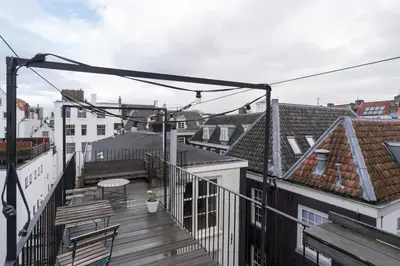 a balcony with a view of the roofs of buildings at Prinsen Terrace - Boutique apartment in the Centre in Amsterdam
