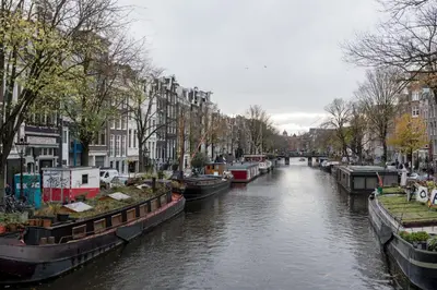 a river with several boats in a city at Prinsen Terrace - Boutique apartment in the Centre in Amsterdam