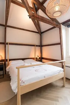 a bed with a wooden frame in a room at Prinsen Terrace - Boutique apartment in the Centre in Amsterdam