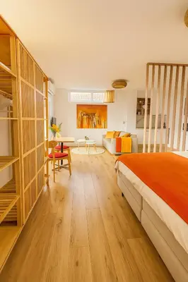 a bedroom with a bed and a living room at De Strandgaper Egmond in Egmond aan den Hoef