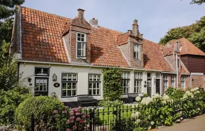 a large white house with a red roof at De Strandgaper Egmond in Egmond aan den Hoef