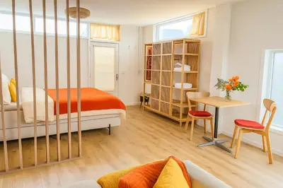 a bedroom with a bed and a desk and a table at De Strandgaper Egmond in Egmond aan den Hoef