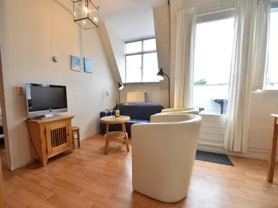 a living room with a couch and a tv at Stay in Bergen aan Zee in Bergen aan Zee