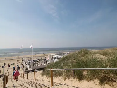 a group of people walking down the stairs to the beach at Stay in Bergen aan Zee in Bergen aan Zee