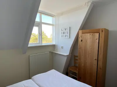 a small room with a bed and a window at Stay in Bergen aan Zee in Bergen aan Zee