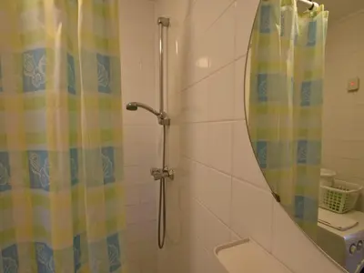 a shower with a mirror and a shower curtain at Stay in Bergen aan Zee in Bergen aan Zee