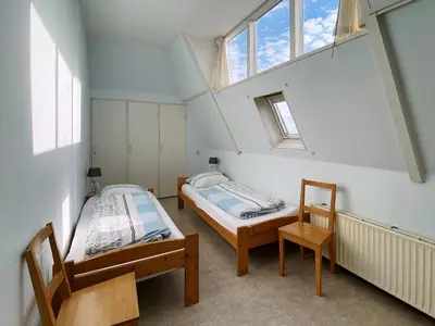 two beds in a room with two windows at Apartment in Bergen aan Zee near Beach in Bergen aan Zee